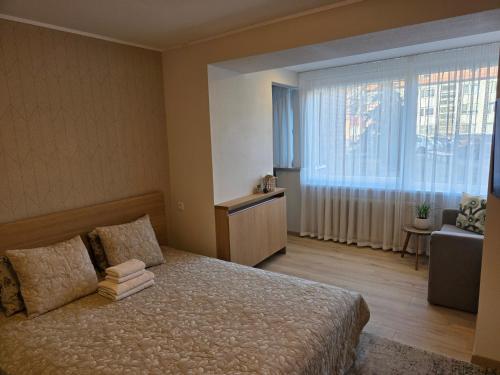 a bedroom with a bed and a large window at Nidos centras -Taikos g in Nida