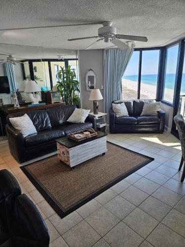 a living room with a couch and a table at Beachfront Condo Panama City Beach Gulf Front Views walk to Pineapple Willy's in Panama City Beach