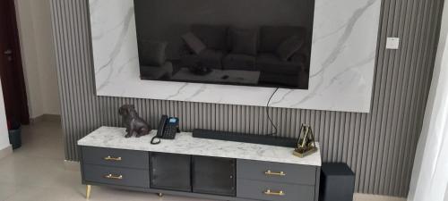 a television on a wall above a dresser with a couch at Easy stays baobab in Mombasa