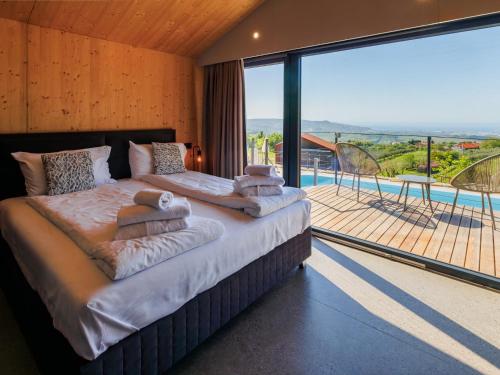 a bedroom with a large bed and a large window at Wine Paradise - Glamping resort in Marezige