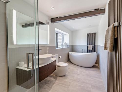 a bathroom with a tub and a toilet and a sink at 5 Bed in Halifax oc-96061 in Sowerby Bridge