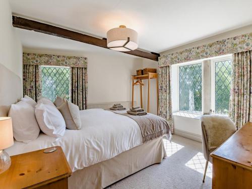 a bedroom with a bed and a desk and windows at 5 Bed in Halifax oc-96061 in Sowerby Bridge