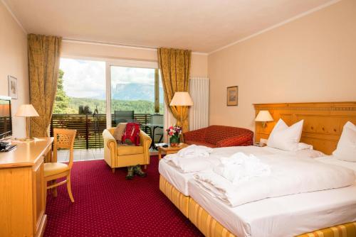 a hotel room with a bed and a desk at Hotel Regina in Soprabolzano