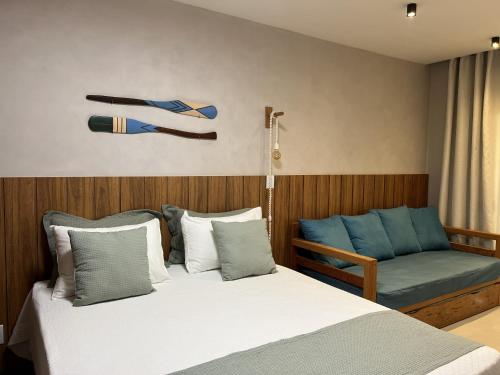 a bedroom with a bed and a couch at Sol de Marau - Taipu de Fora - próximo das piscinas naturais in Marau