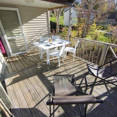 a white table and chairs on a deck at Camping Lac aux Oiseaux - Mobil-home 3 Pièces 4 Personnes MAE-0991 in Martiel