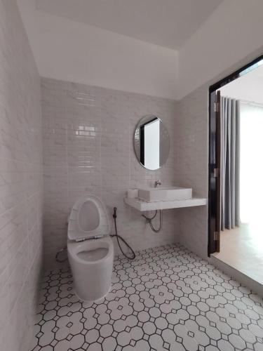 a bathroom with a toilet and a sink and a mirror at Harmony Villa in Wok Tum
