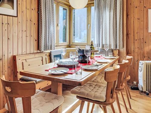 a dining room with a long wooden table and chairs at Chalet Chalet chemin du four by Interhome in Morgins