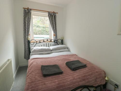 a bedroom with a bed with two towels on it at 23 Beach Road in Y Felinheli