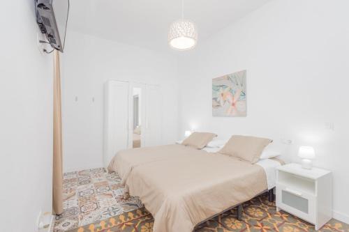 a white bedroom with a bed and a table at GuestReady - Refugio de Salome in Los Sauces