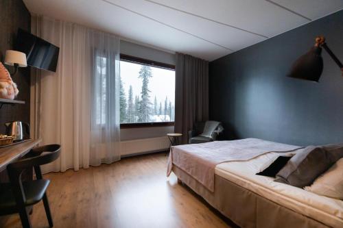 ein Schlafzimmer mit einem Bett und einem großen Fenster in der Unterkunft Santa's Hotel Aurora & Igloos in Luosto