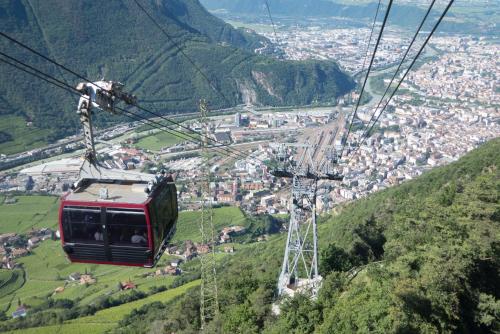 a cable car in the mountains with a city at Hotel Regina in Soprabolzano