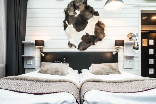 a bedroom with two beds and a cow headboard at Santa's Igloos Arctic Circle in Rovaniemi