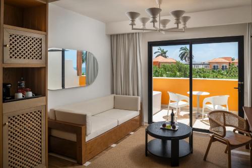a bedroom with a bed and a balcony with a table at El Beso at Ocean Coral & Turquesa All Inclusive in Puerto Morelos