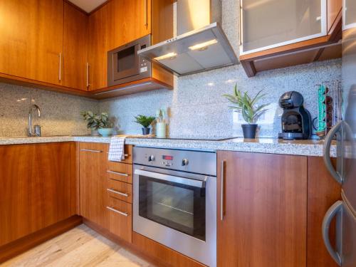 a kitchen with wooden cabinets and a stove top oven at Studio Justina by Interhome in L'Ampolla