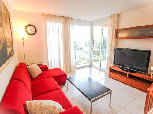 a living room with a red couch and a tv at Apartment Sa Guilla by Interhome in Pals