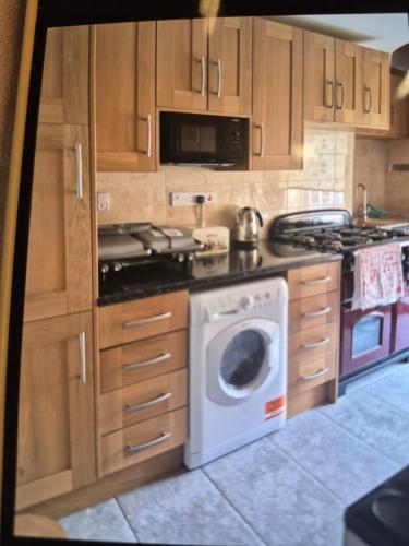 a kitchen with a stove and a washing machine at 8 River view in King's Lynn