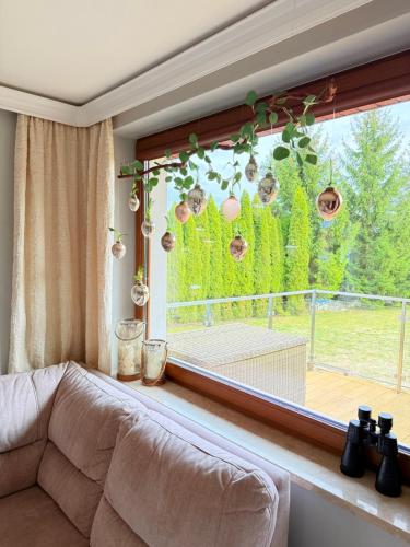 a living room with a couch and a large window at Apartamenty Euphoria in Gołdap