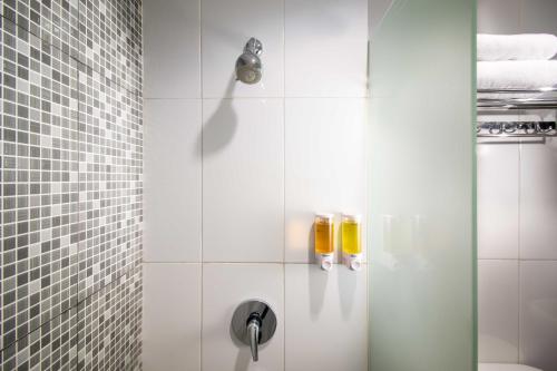 a shower with a glass door with two bottles at Hotel 88 Mangga Besar 62 Lokasari By WH in Jakarta