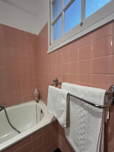 a bathroom with a bath tub and towels on a rack at Studio Climatisé au centre ville in Digoin