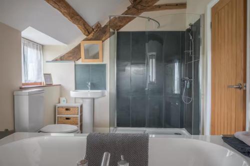 a bathroom with a tub and a toilet and a sink at Spacious Barn Conversion 4 Bedroom Hot Tub - Pass the Keys in Seathwaite