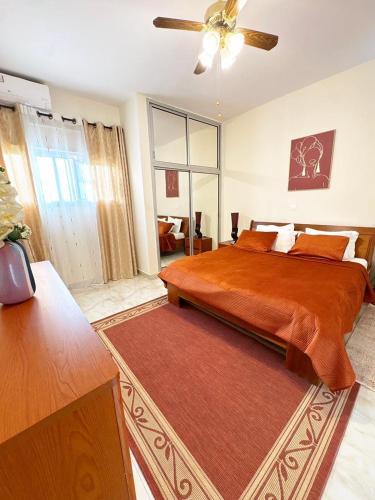 a bedroom with a large bed and a ceiling fan at Residence ocean view in Ngor