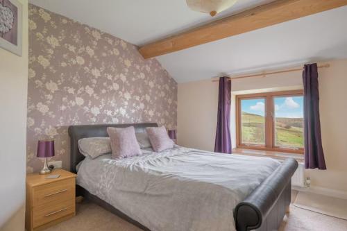 a bedroom with a bed and a window at Spacious Barn Conversion 4 Bedroom Hot Tub - Pass the Keys in Seathwaite
