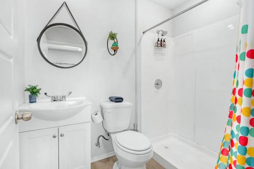 a bathroom with a toilet and a sink and a mirror at The Container Retreat - 2B in Canyon Lake