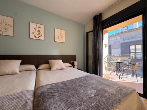 a bedroom with a bed and a balcony with a table at Casa Polaco in Valderrobres