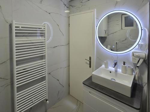 a bathroom with a sink and a mirror at Sarajevo Central View Apartment in Sarajevo