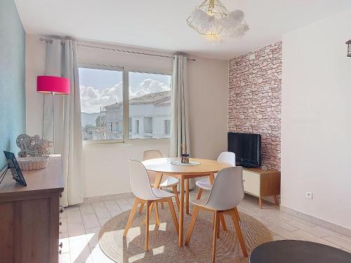a dining room with a table and chairs and a television at Apartment U Centru by Interhome in Porto-Vecchio