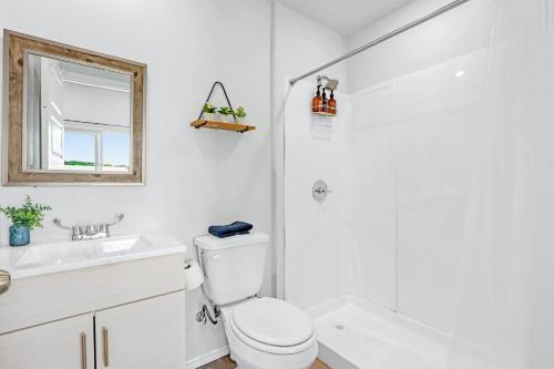 a white bathroom with a toilet and a sink at The Container Retreat - 3B in Canyon Lake