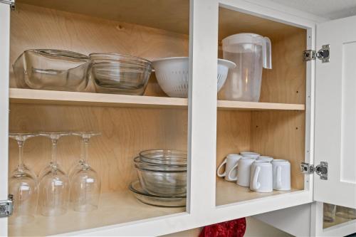 a kitchen cabinet filled with glass dishes and bowls at Oceanfront Bay Watch 1BR with Resort Amenities 1707 in Myrtle Beach