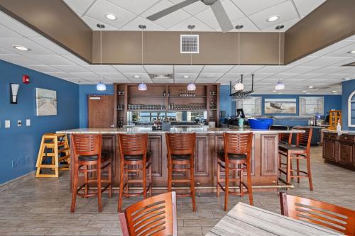 a large kitchen with a bar with wooden stools at Oceanfront Bay Watch 1BR with Resort Amenities 1707 in Myrtle Beach