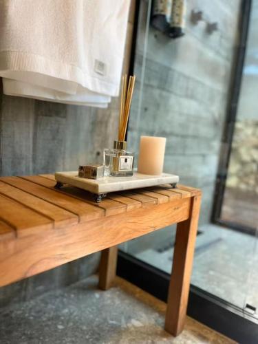 a wooden table with a clock on top of it at Cabana Encanto A-FRAME Com Cachoeira in Bocaina de Minas