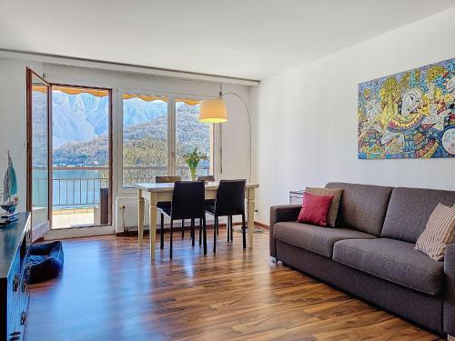 a living room with a couch and a table with chairs at Apartment Vico Morcote Luxury View Apartment by Interhome in Morcote