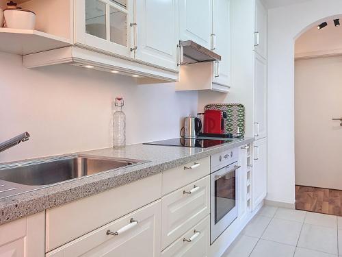 a kitchen with white cabinets and a sink at Apartment Vico Morcote Luxury View Apartment by Interhome in Morcote