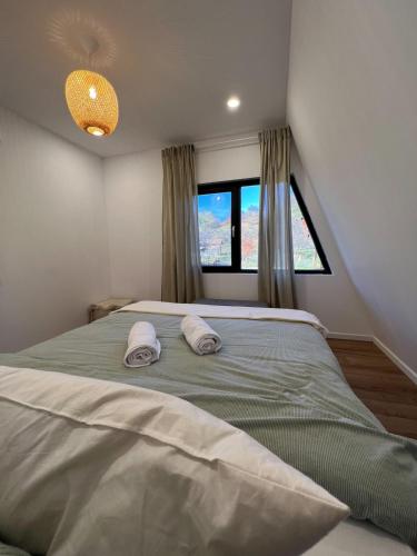a bedroom with a large bed with two towels on it at Skyframe Cabin in Pucheni