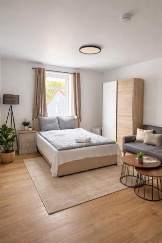 a white bedroom with a bed and a couch at Oishi Ngon 19 in Wutha-Farnroda