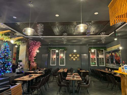 a restaurant with tables and chairs and a christmas tree at Oishi Ngon 19 in Wutha-Farnroda