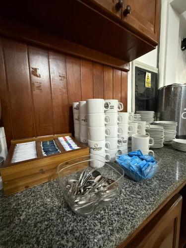 a kitchen counter with cups and utensils on it at HOTEL DIAMANTE in Resistencia