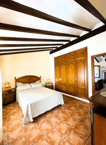 a bedroom with a bed and wooden cabinets at Villa con piscina y barbacoa en Calpe in Calpe
