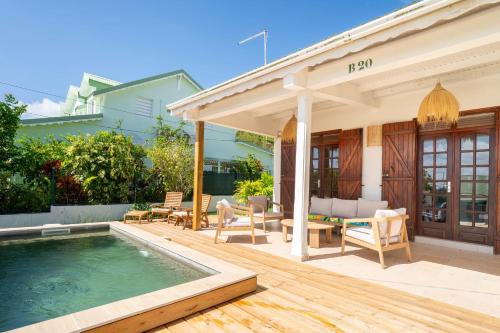 a backyard with a pool and a house at Villa Bleue Papaye in Grand-Bourg