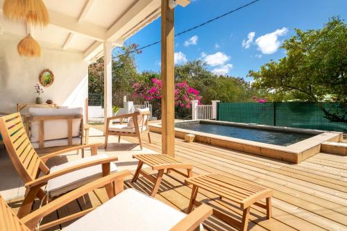 a deck with chairs and a swimming pool at Villa Bleue Papaye in Grand-Bourg