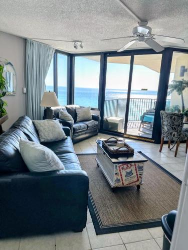 a living room with a couch and a table at Beachfront Condo Panama City Beach Gulf Front Views walk to Pineapple Willy's in Panama City Beach