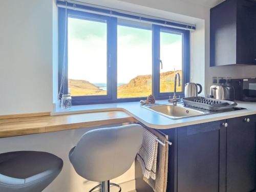 a kitchen with a sink and a chair and a window at Chalet The Studio by Interhome in Glendale