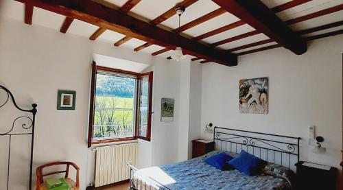 a bedroom with a bed and a large window at Agriturismo PEDROSOLA in Brisighella