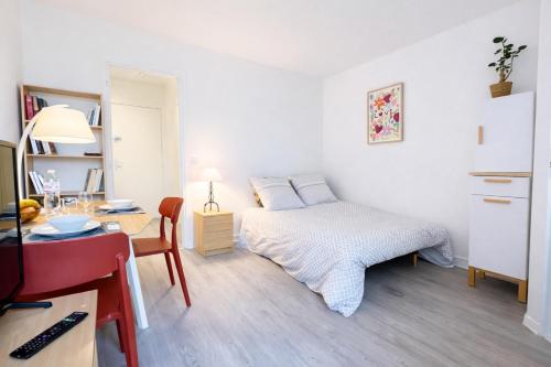 a small bedroom with a bed and a desk at Relax-Parc des expos-Wifi by La clé des expos in Vanves