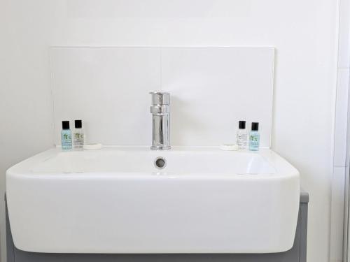 a white bathroom sink with two toothbrushes on it at Orchard Mews , Barnham in Barnham