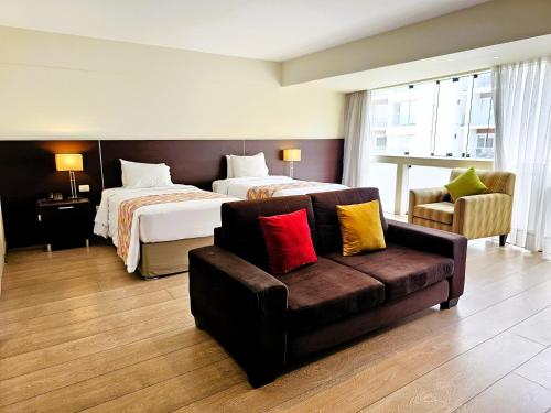 a hotel room with a bed and a couch at Diez Canseco by 2W Aparments Service in Lima
