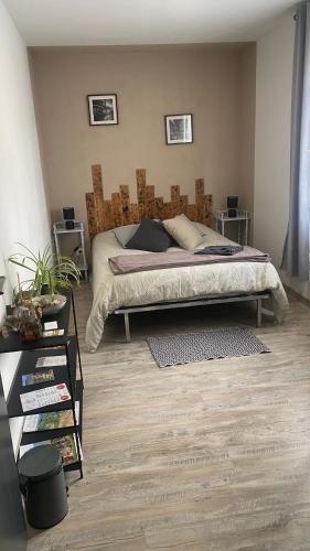 a bedroom with a bed with a wooden headboard at Chambre chez l habitant Audrey in Saligny-sur-Roudon